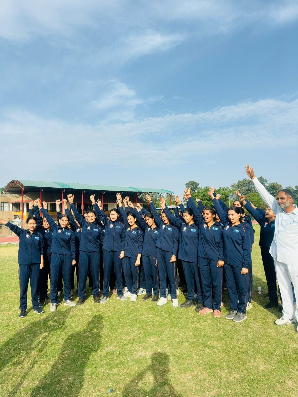 Women recruits raise their fists in celebration alongside their trainer at a Project Virangana training camp run by Shakti Udghosh in Jammu Kashmir